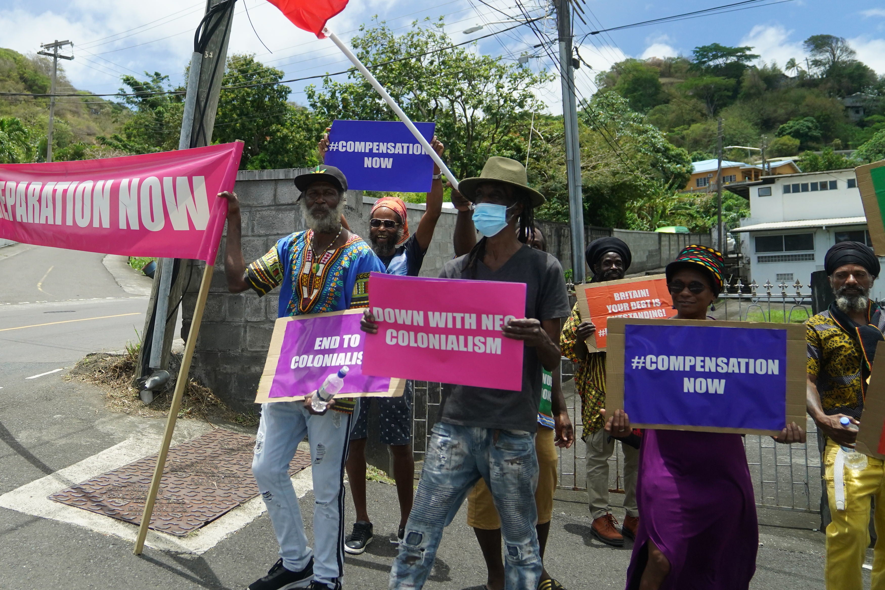 Protesters with with banners protesting against British colonialism as the Earl and the Countess of Wessex arrive at Government House in St Vincent and the Grenadines