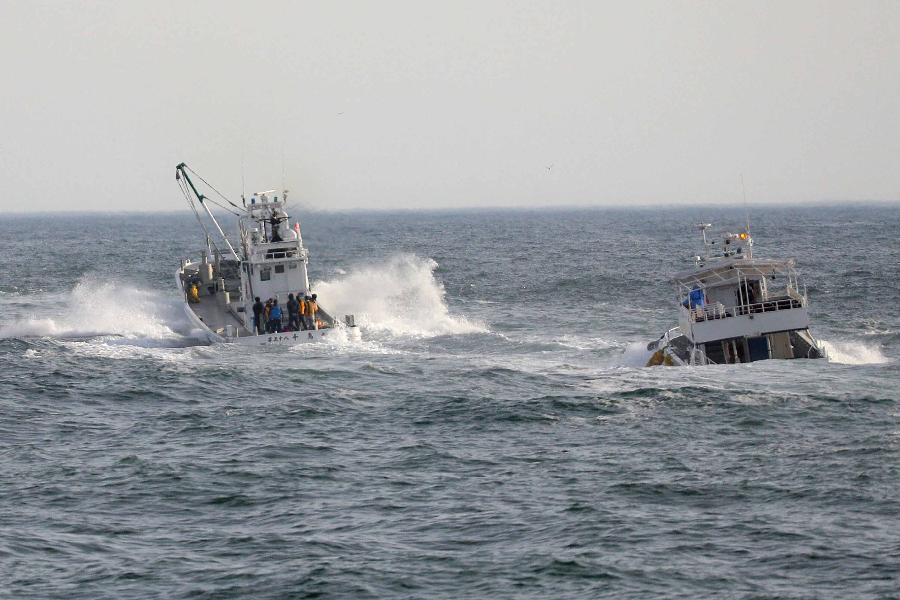 Fishing boats conduct a search operation for missing people aboard the ‘Kazu 1‘ sightseeing boat