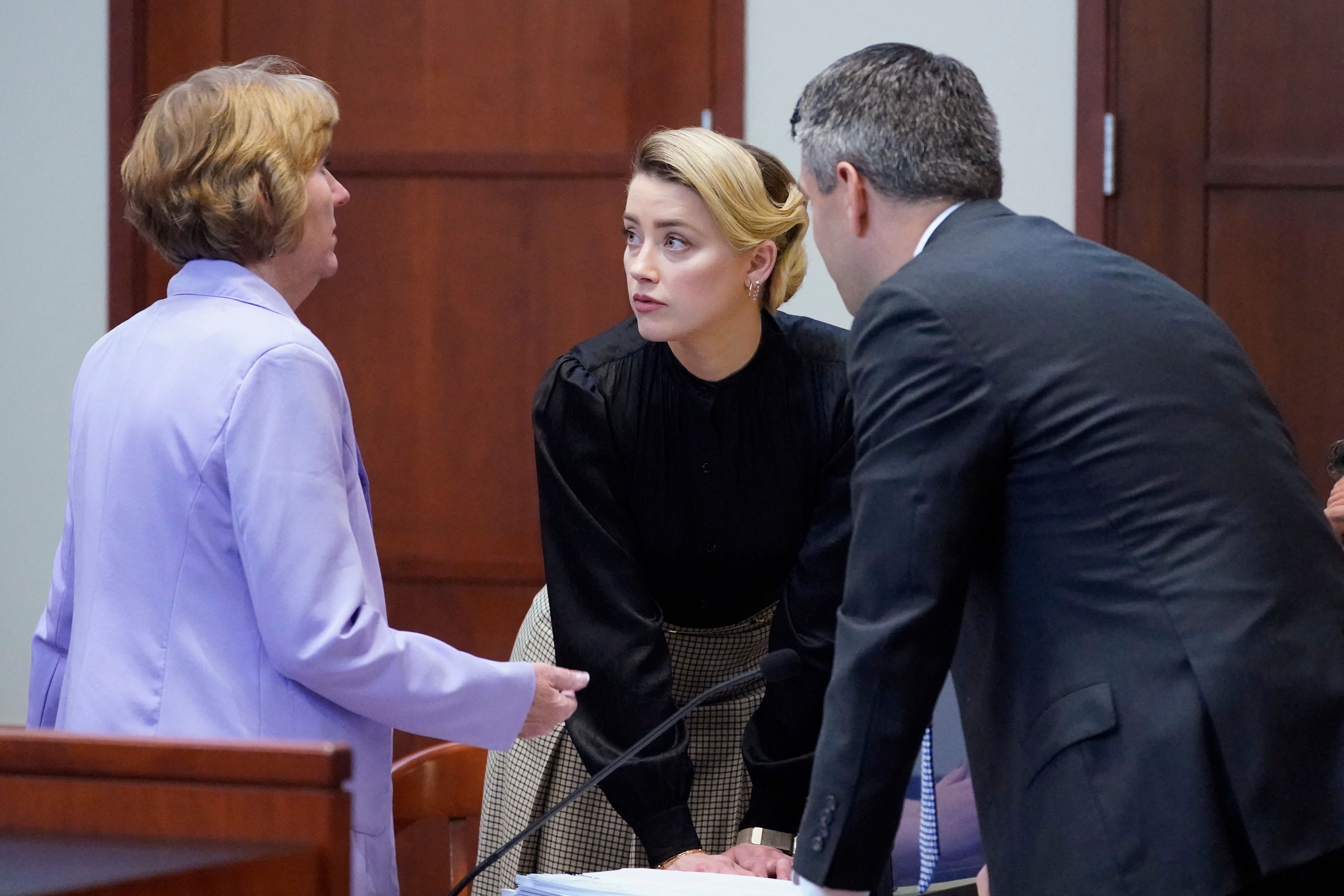 Amber Heard talks to her attorneys in a courtroom at the Fairfax County Courthouse in Fairfax, Virginia on 25 April 2022