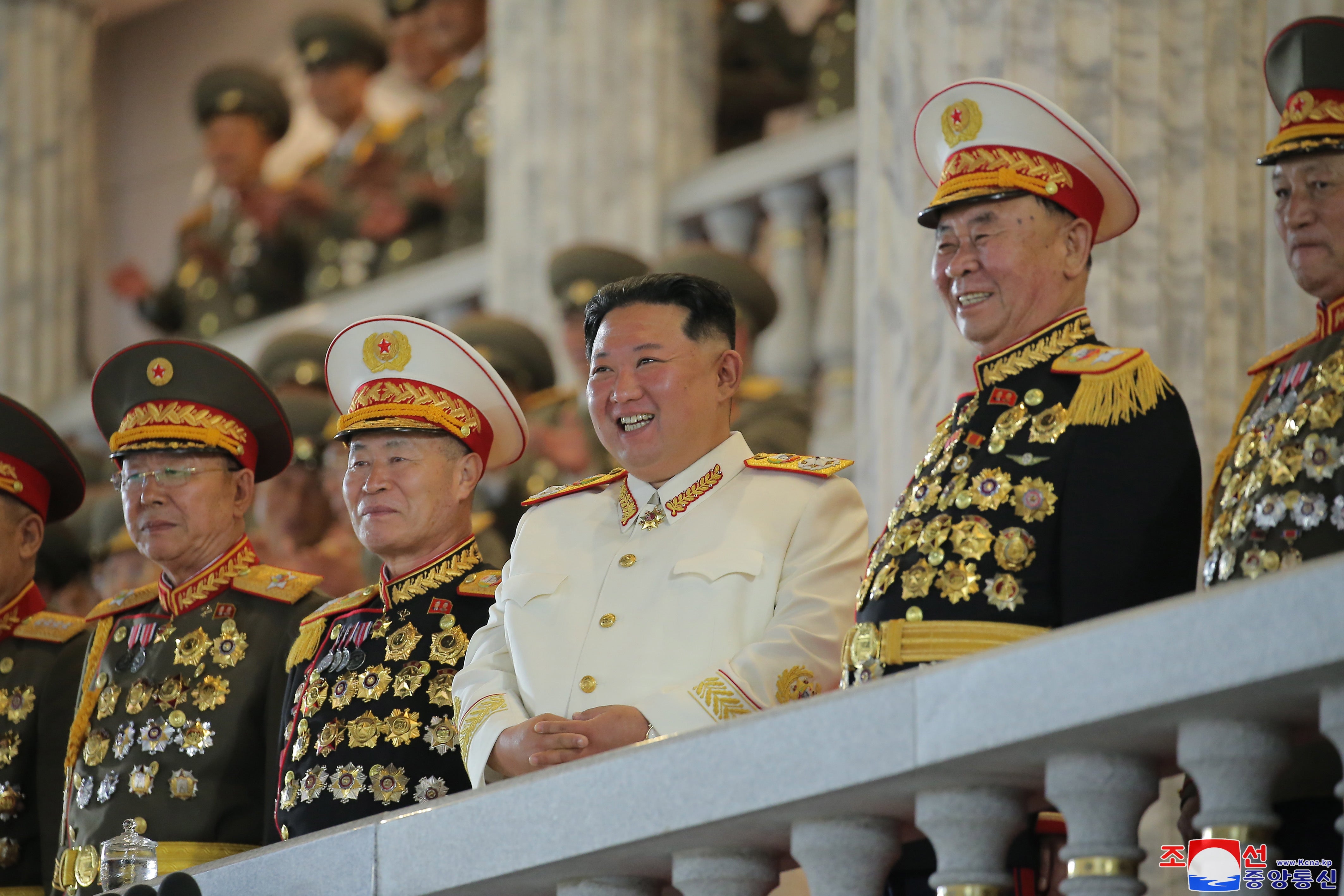 A photo released by the state-run North Korea news agency shows Kim, centre, presiding over a military parade