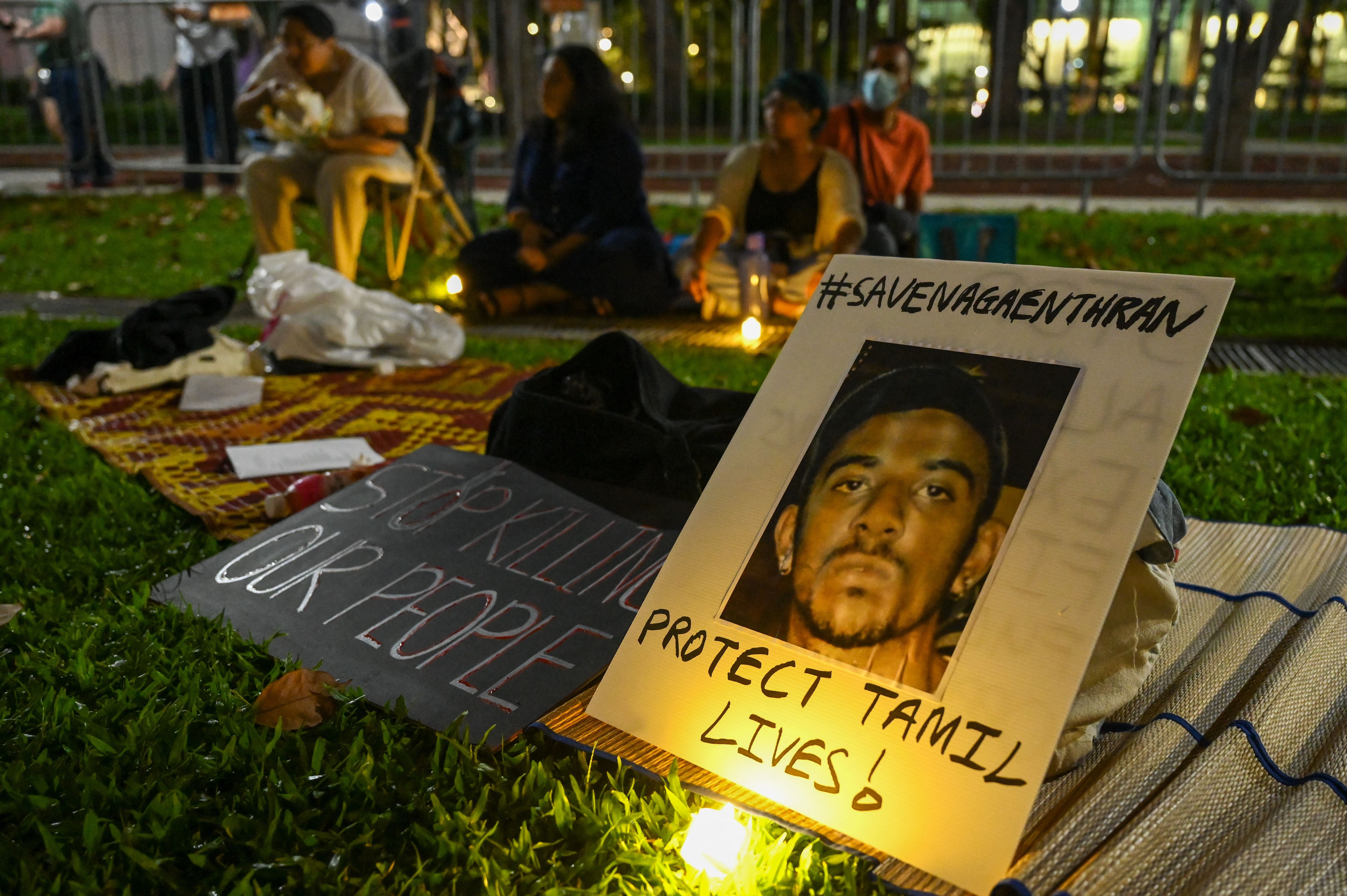 People display placards and during a vigil for Malaysian national Nagaenthran Dharmalingam, sentenced to death for trafficking heroin into Singapore