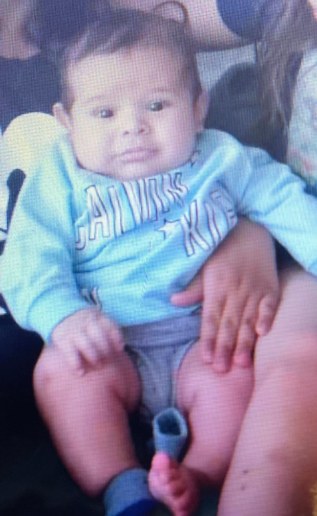 The 3-month-old baby, Brandon Cuellar, was abducted by a man the family does not recognize, police said. He was wearing a white long sleeve onesie with dinosaurs on it.