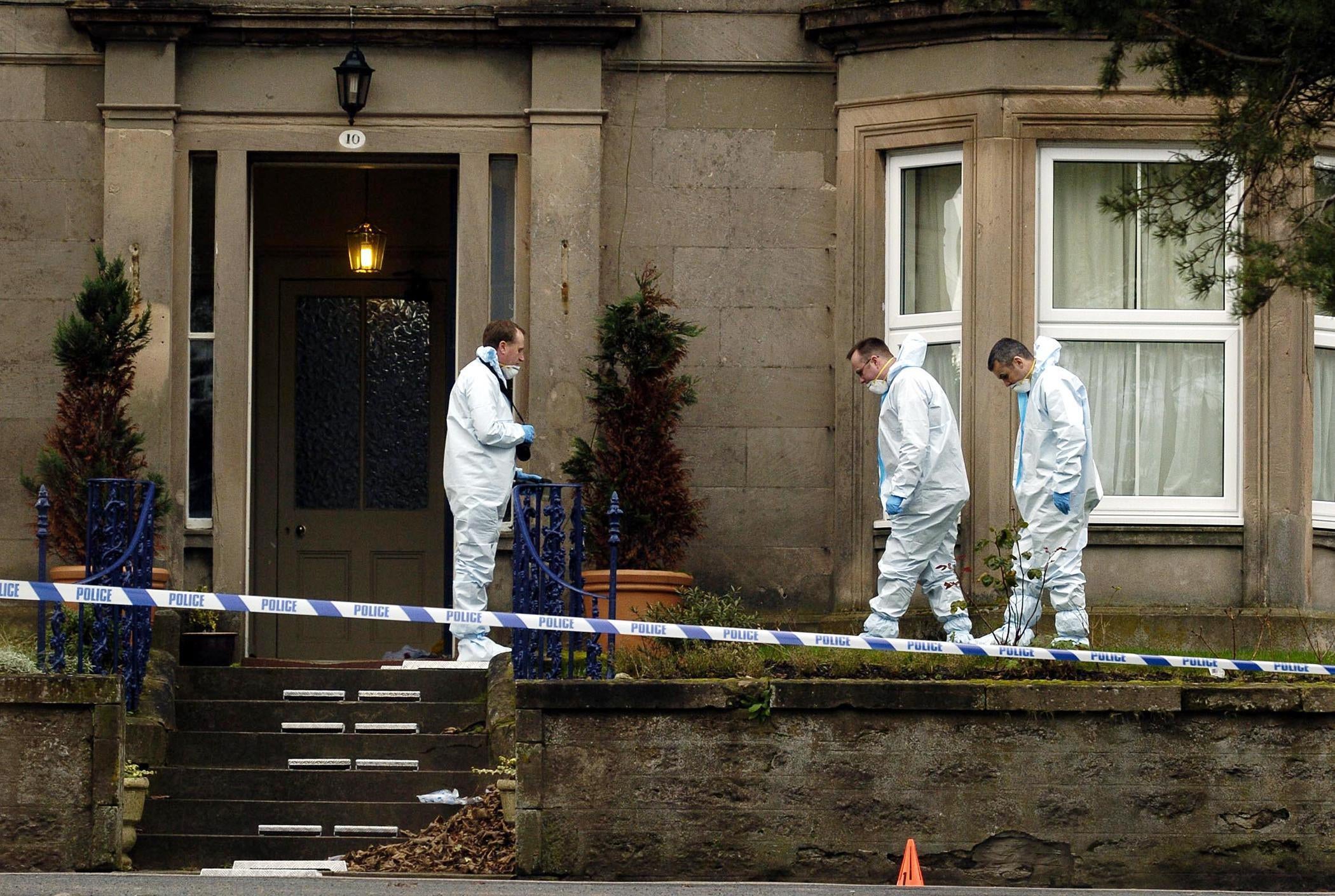 Forensic teams examine the front garden of the home of bank manager Alistair Wilson, in Nairn, Nairnshire, after he was gunned down on his doostep
