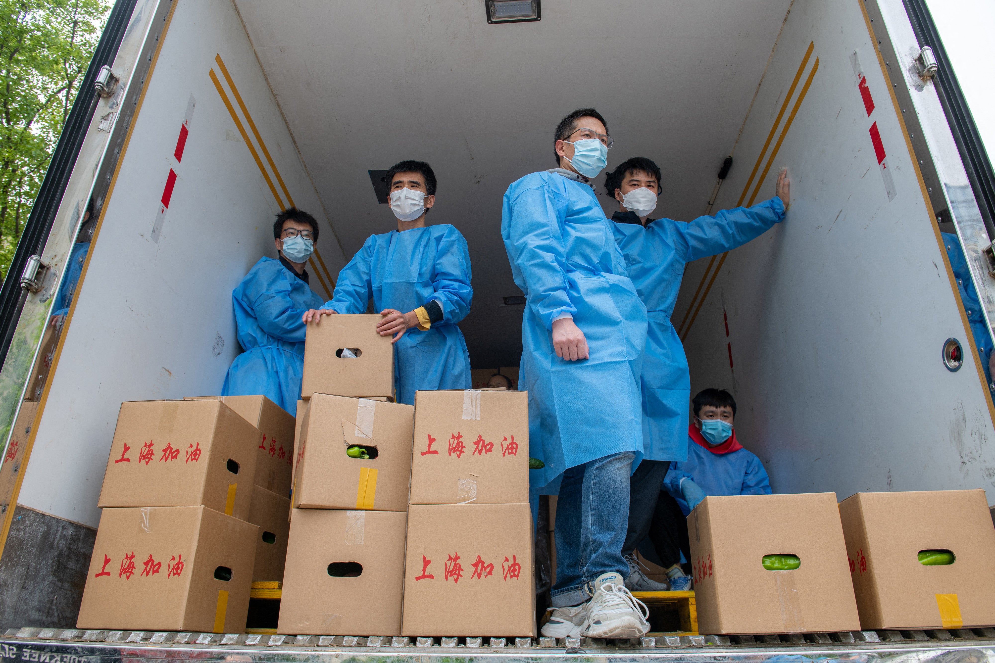 Community volunteers prepare to deliver boxes of food which are distributed by local government to residents in Pudong district in Shanghai on April 15, 2022