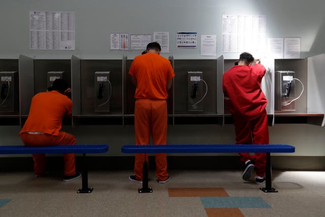 <p>Detainees talk on telephones at the Adelanto ICE Processing Center in Adelanto, Calif</p>