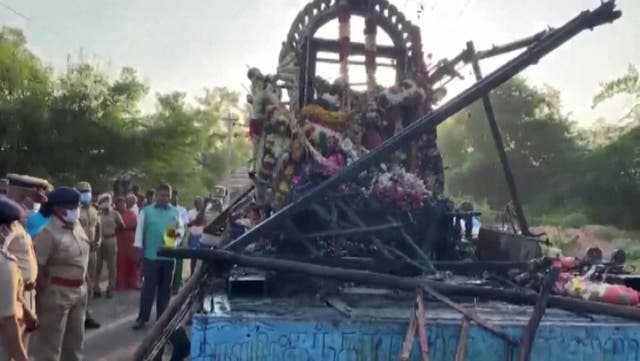 <p>People gather around a chariot that was damaged after a high voltage power wire fell on it, killing at least 11 people, during a procession in a temple festival in Kalimedu village</p>