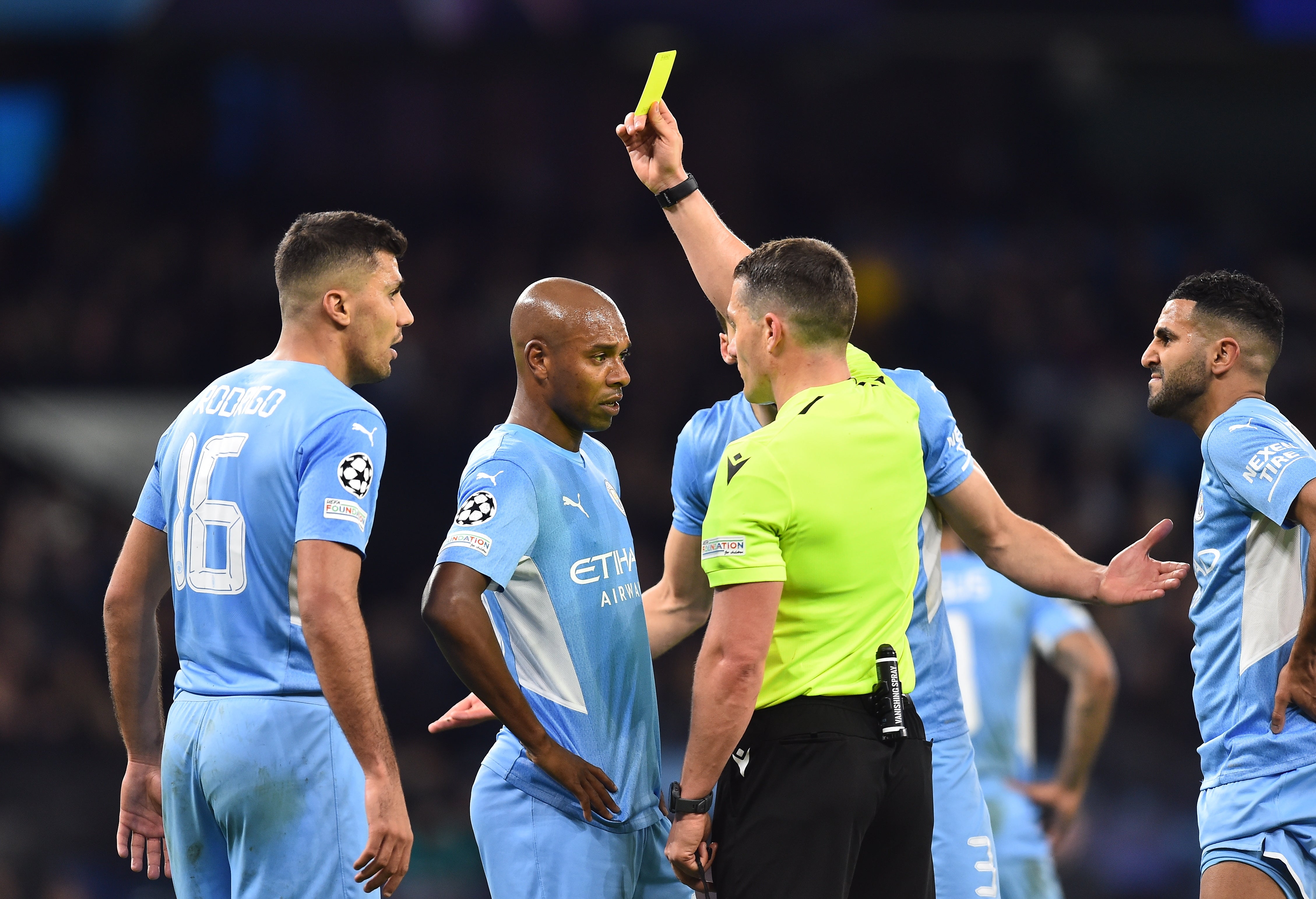 Referee Istvan Kovacs shows the yellow card to Manchester City’s Fernandinho