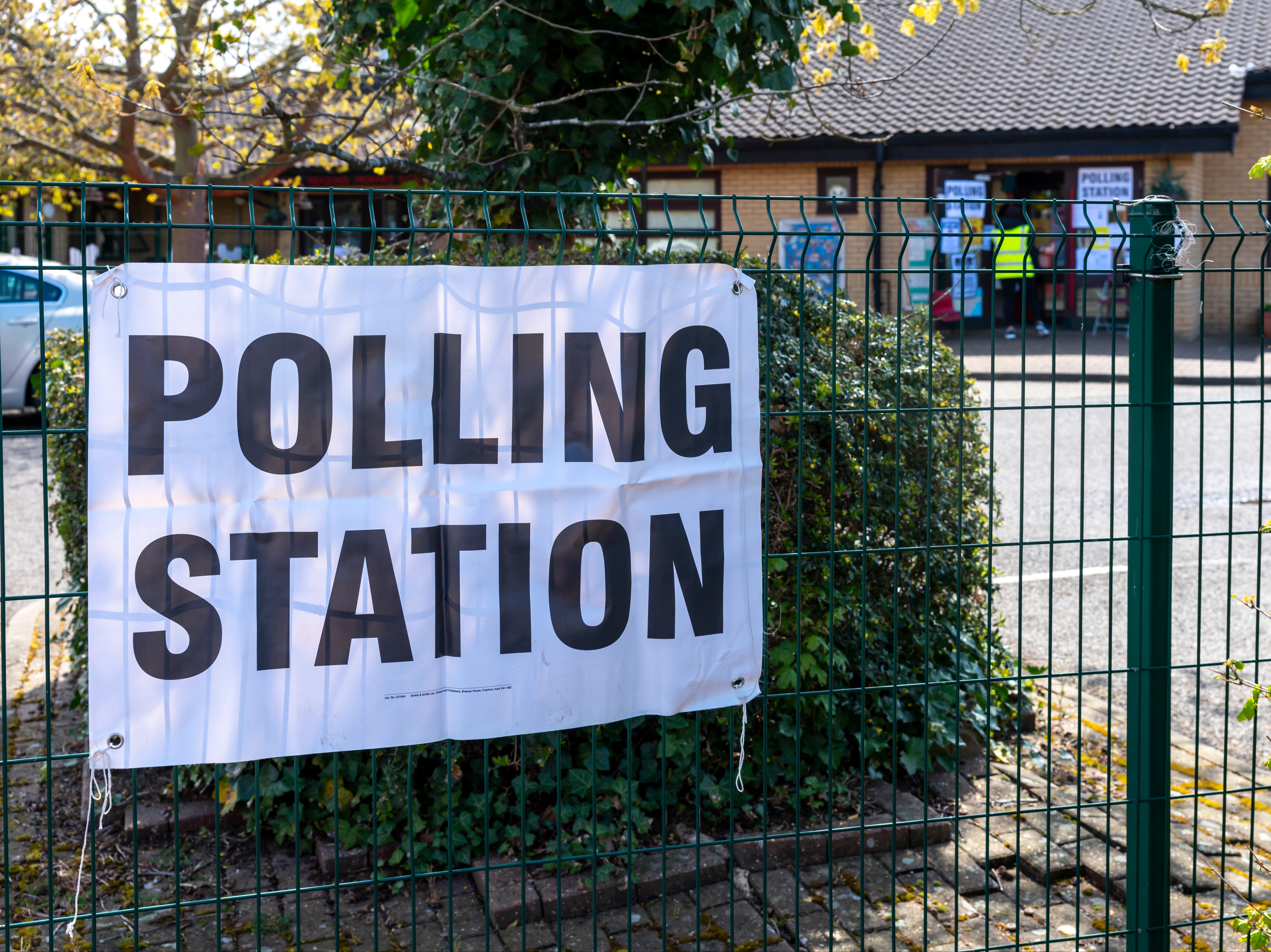 A polling station sign outside of a school