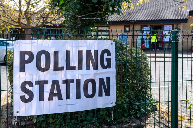 <p>A polling station sign outside of a school </p>