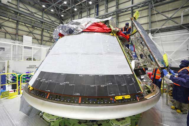 <p>Technicians add panels to the Boeing Starliner spacecraft at Kennedy Space Center ahead of an Orbital test flight scheduled for May</p>