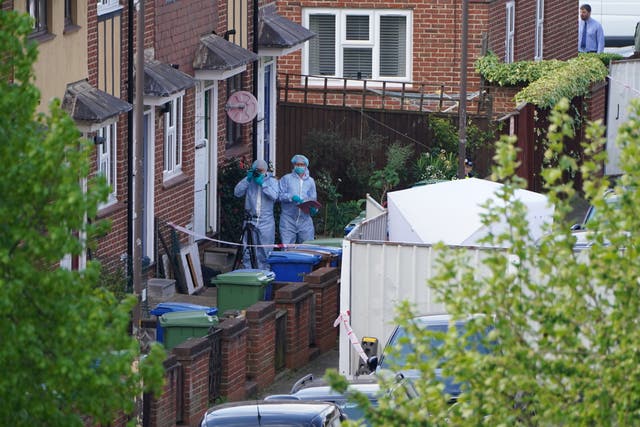Police officers in forensic suits enter a house in Bermondsey, south-east London (PA)
