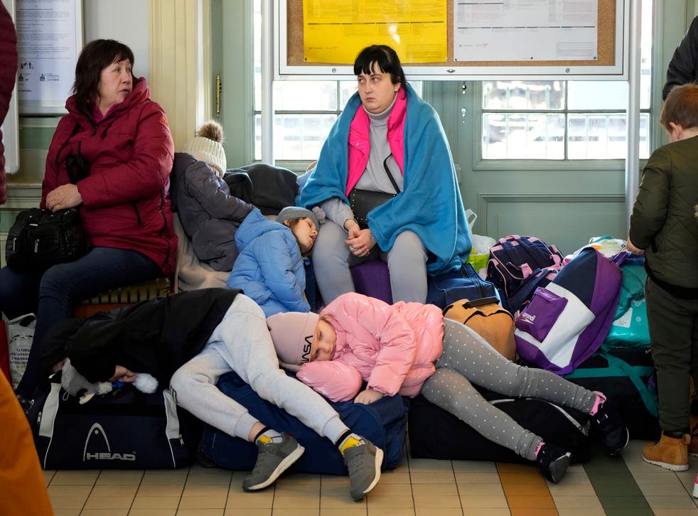 FILE – Children from Ukraine sleep on luggage at a railway station in Przemysl, southeastern Poland, on Wednesday, March 23, 2022. The U.N. refugee agency says more than 5 million refugees have fled Ukraine since Russian troops invaded the country. The agency announced the milestone in Europe’s biggest refugee crisis since World War II on Wednesday, April 20, 2022. (AP Photo/Sergei Grits, File)