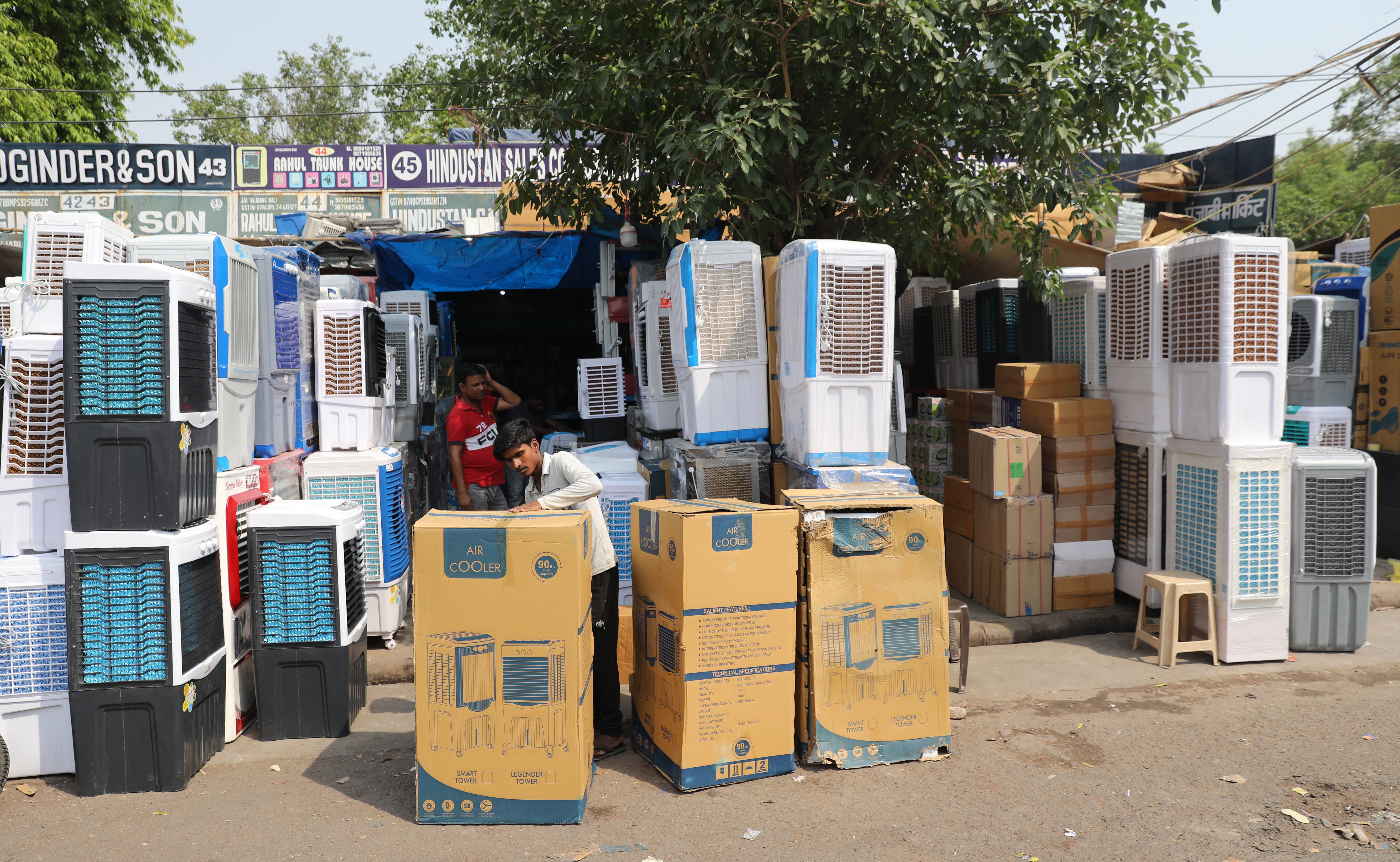 An Indian worker displays air coolers for sale as the temperature rises in New Delhi, 28 April 2022