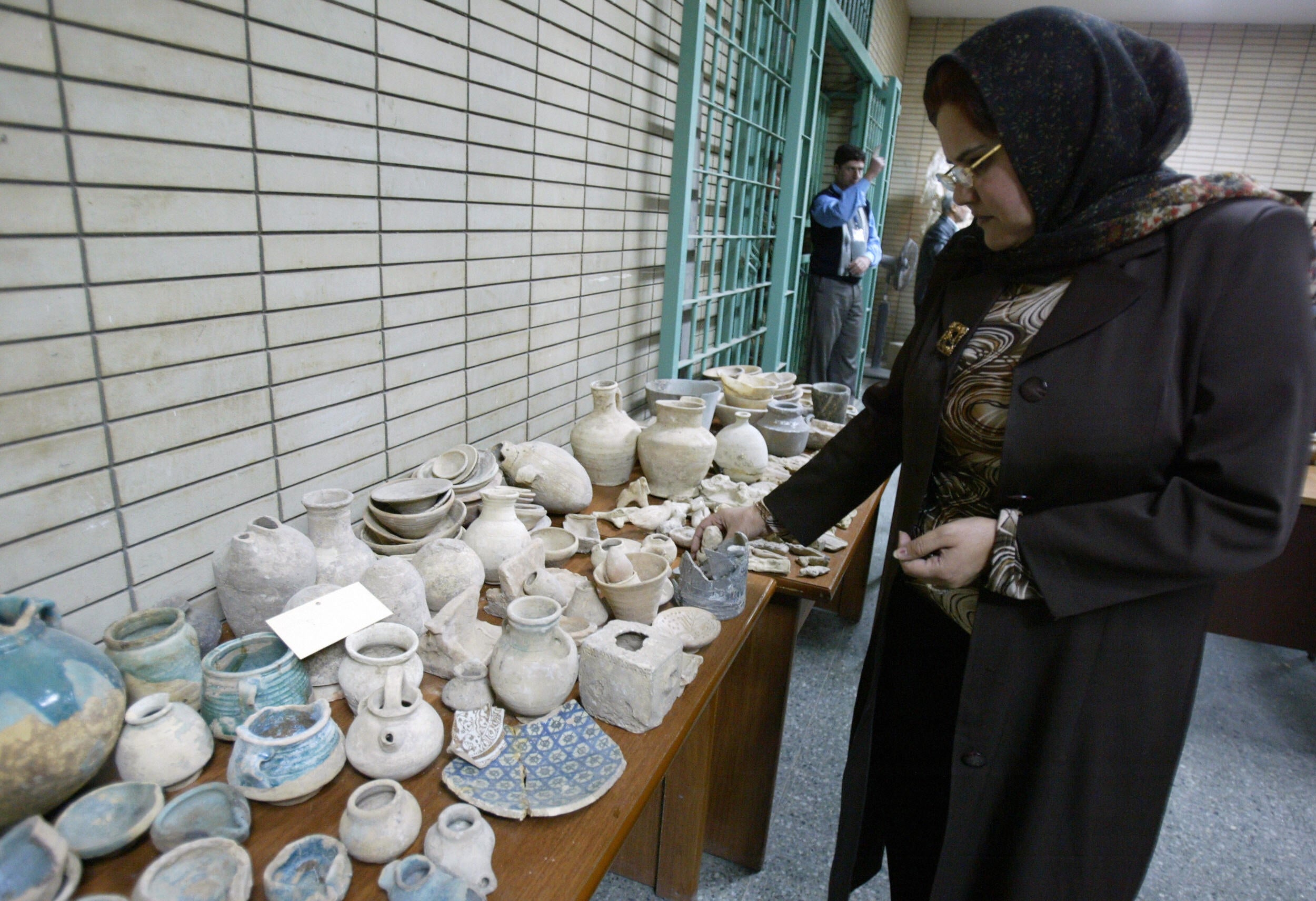 An Iraqi archaeologist inspects ancient pottery displayed at the national museum in Baghdad