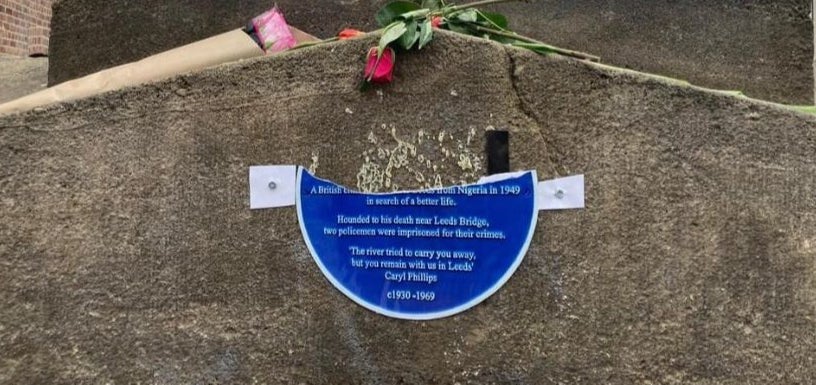 A temporary plaque installed to replace the stolen original has been torn in two