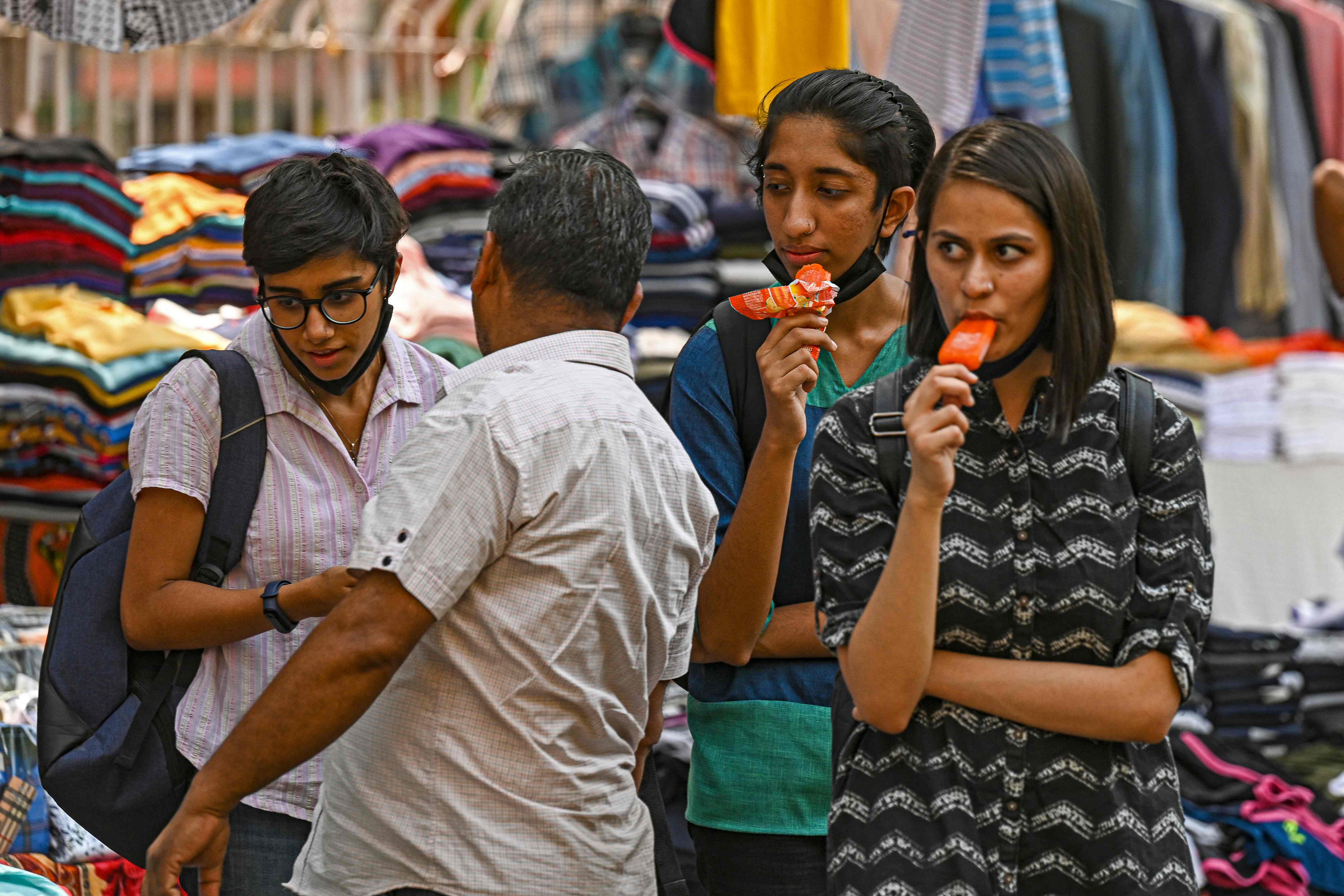 Girls have ice creams while shopping on a hot summer afternoon in New Delhi on 28 April 2022