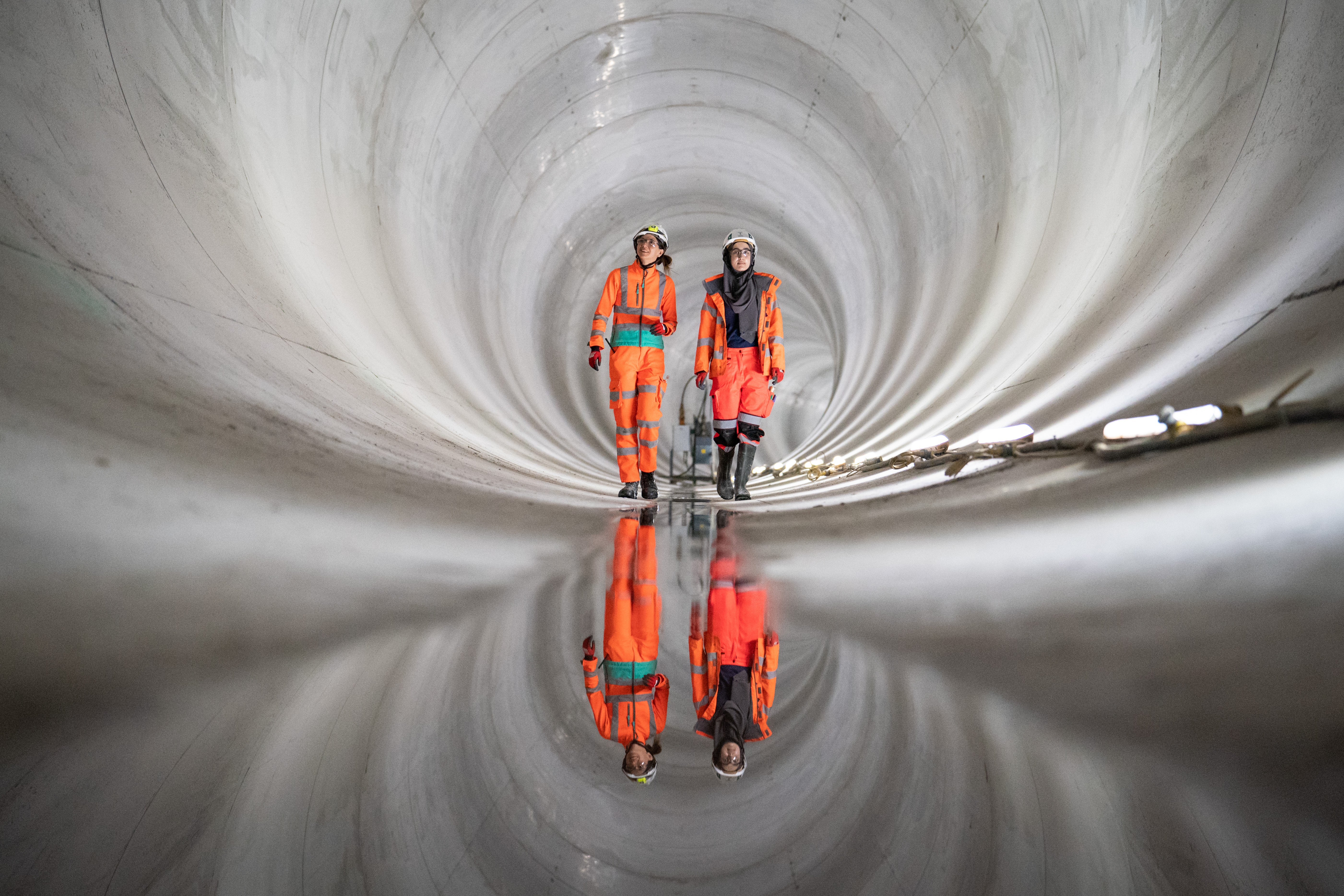 Construction workers walk in a completed section of the main tunnel of London’s new 25km long Thames Tideway Tunnel (PA/Dominic Lipinski)