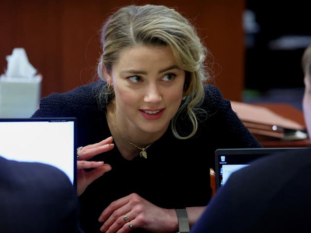 La actriz Amber Heard habla con su equipo legal durante el juicio por difamación de su exmarido Johnny Depp en su contra, en el juzgado de circuito del condado de Fairfax en Fairfax, Virginia, EE. UU., el 28 de abril de 2022.