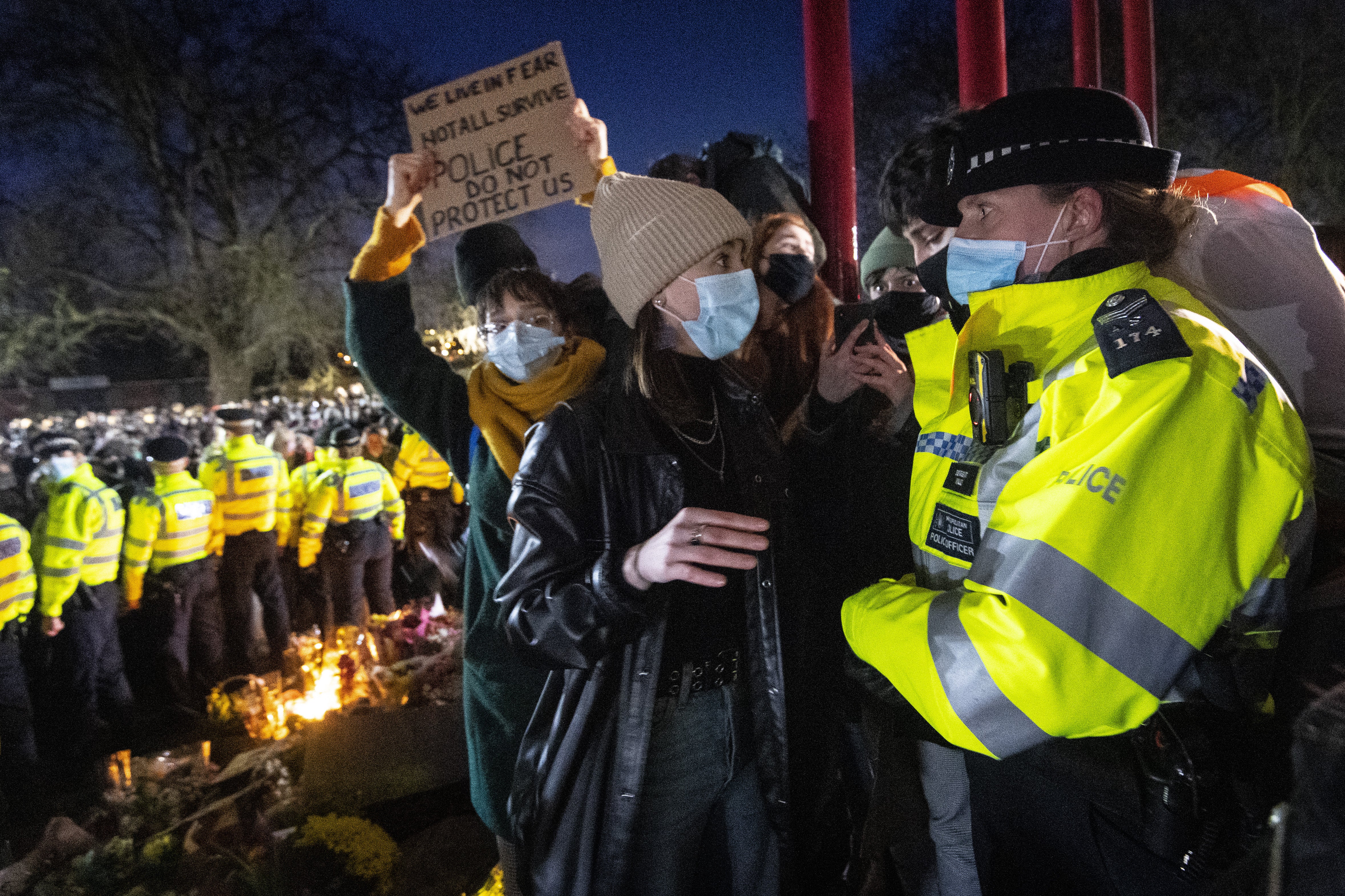 A woman talks to a police officer during a gathering in Clapham Common, London, after the Reclaim These Streets vigil for Sarah Everard was officially cancelled (Victoria Jones/PA)