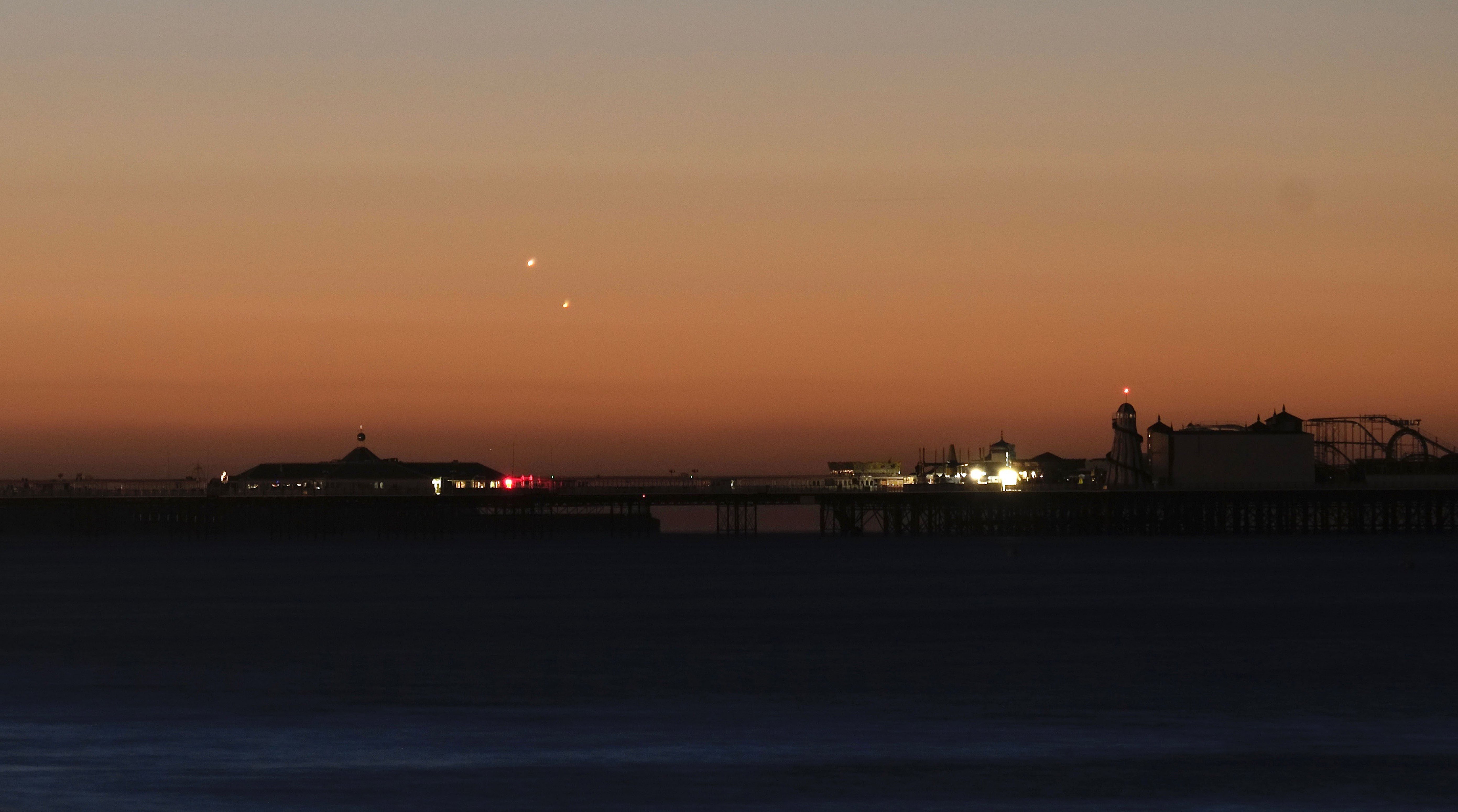 Photo of Venus (left) and Jupiter in the skies over Brighton Pier during a planetary conjunction