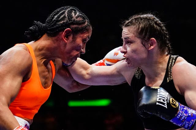 <p>Katie Taylor (right) remained unbeaten and retained her belts with the narrow win</p>