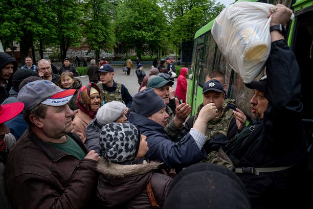 <p>A Police officer, right, distributes humanitarian aid to local residents in Lyman, Donetsk region, eastern Ukraine, Saturday, April 30, 2022 </p>