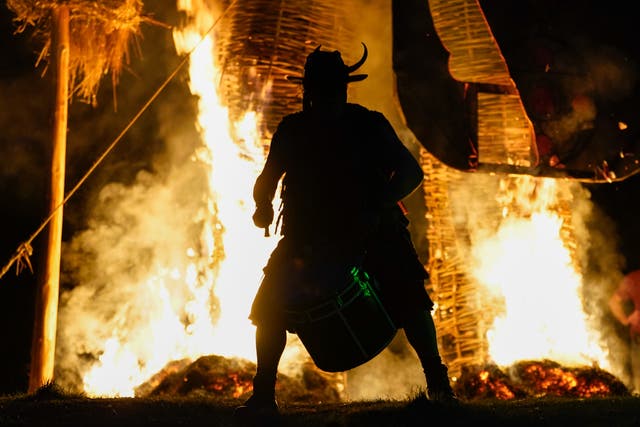 A member of the Pentacle Drummers performs in front of a burning wicker man during the Beltane Festival at Butser Ancient Farm, in Waterlooville, Hampshire (Andrew Matthews/PA)