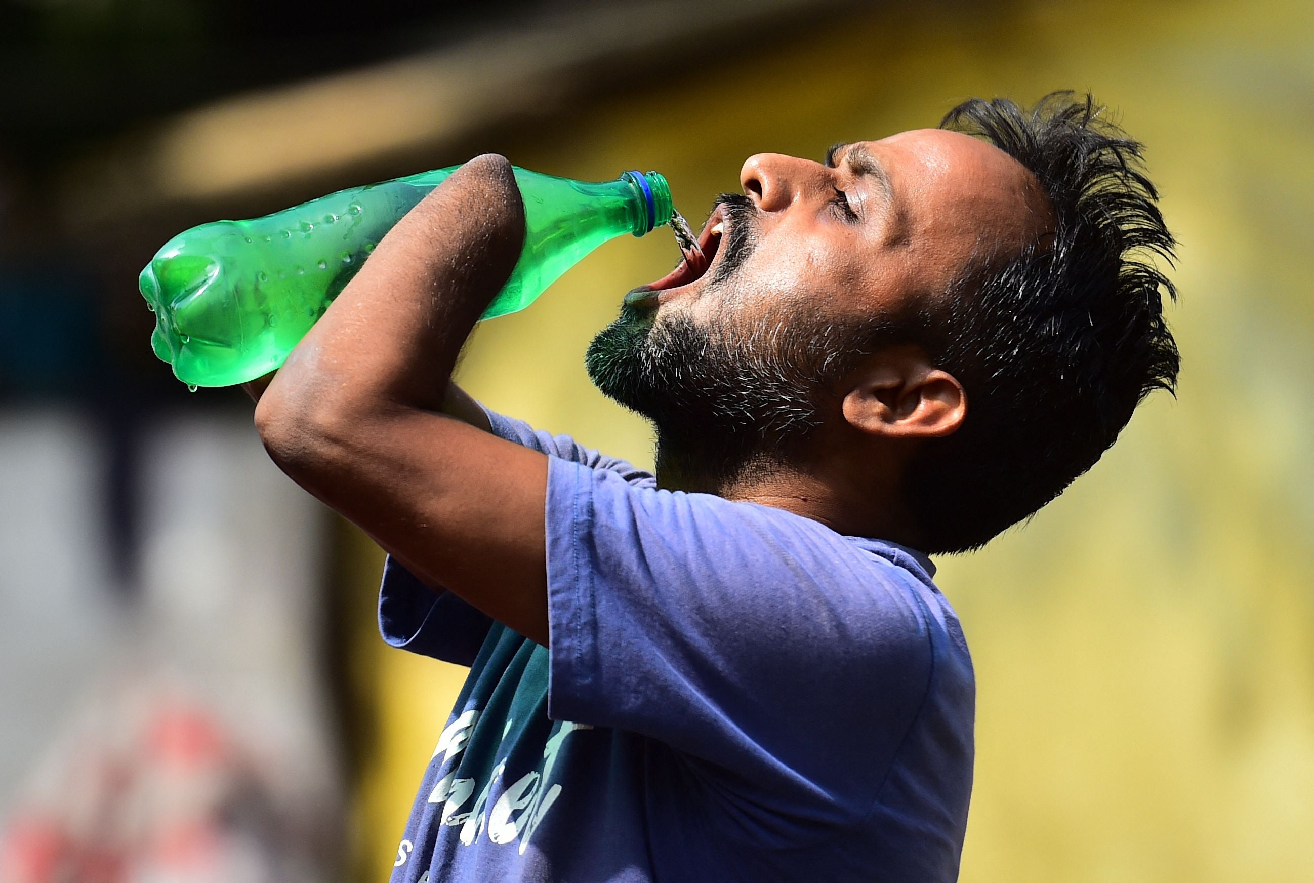 A man drinks water from a bottle in Allahabad, Uttar Pradesh