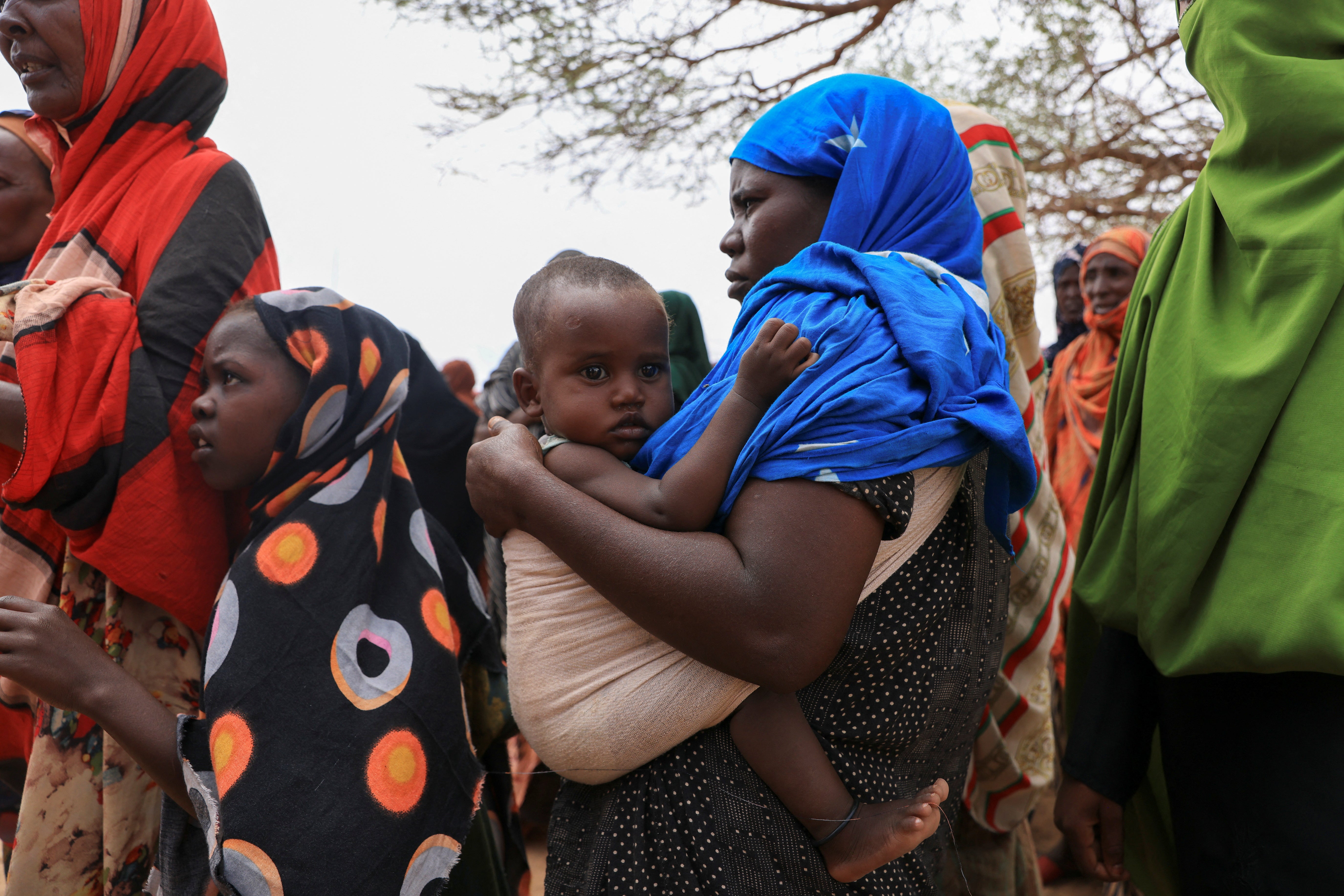 <p>Women queue to receive food aid in the Higlo camp for people displaced by drought, in the town of Gode</p>
