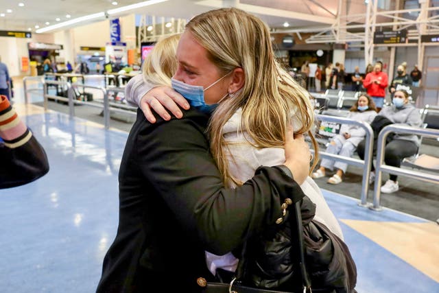 <p>Families embrace after a flight from Los Angeles arrived at Auckland International Airport, as New Zealand’s border opened for visa-waiver countries Monday, 2 May 2022</p>