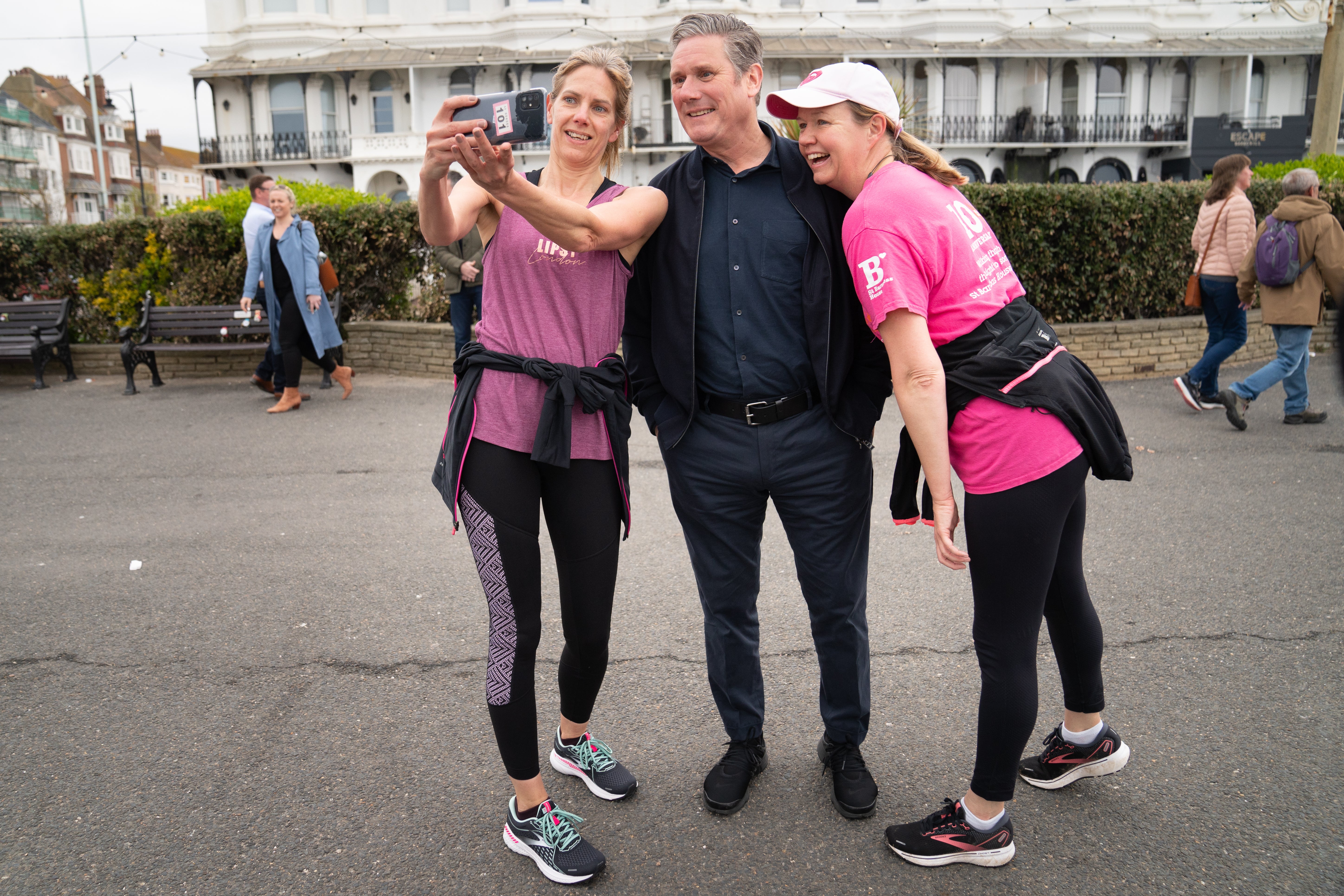 Labour Leader Sir Keir Starmer meets two runners on Worthing sea front in West Sussex while out campaigning (Stefan Rousseau/PA)