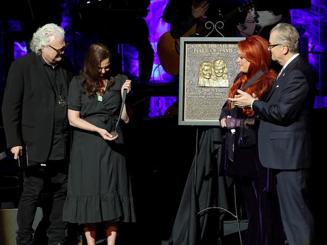 <p>Ashley Judd (CL) accepts induction on behalf of Naomi Judd with Ricky Skaggs(L), inductee Wynonna Judd and CEO of the Country Music Hall of Fame and Museum Kyle Young onstage for the class of 2021 medallion ceremony at Country Music Hall of Fame and Museum. </p>