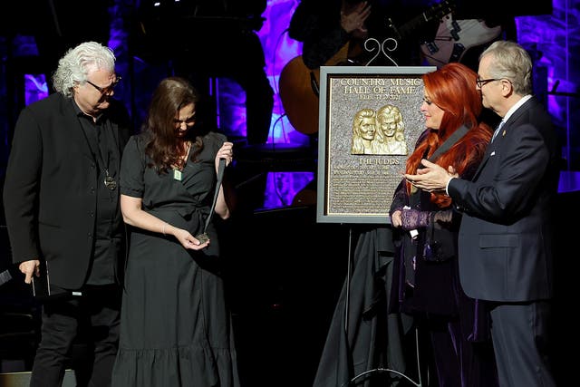 <p>Ashley Judd (CL) accepts induction on behalf of Naomi Judd with Ricky Skaggs(L), inductee Wynonna Judd and CEO of the Country Music Hall of Fame and Museum Kyle Young onstage for the class of 2021 medallion ceremony at Country Music Hall of Fame and Museum. </p>