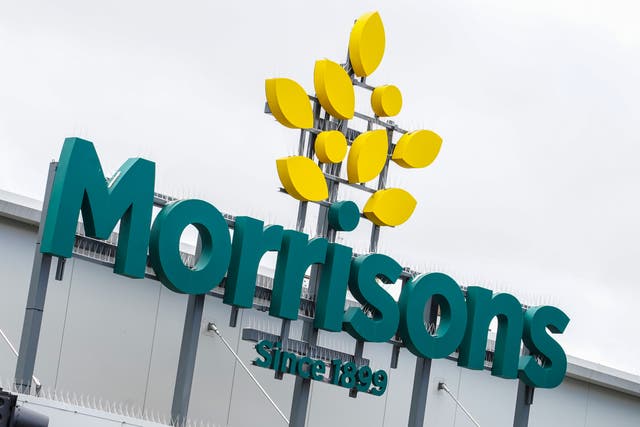 <p>A view of a store sign at a branch of Morrisons supermarket in Camden, London. The supermarket group’s owners have agreed to sell 87 petrol stations to push through the takeover (Ian West/PA)</p>