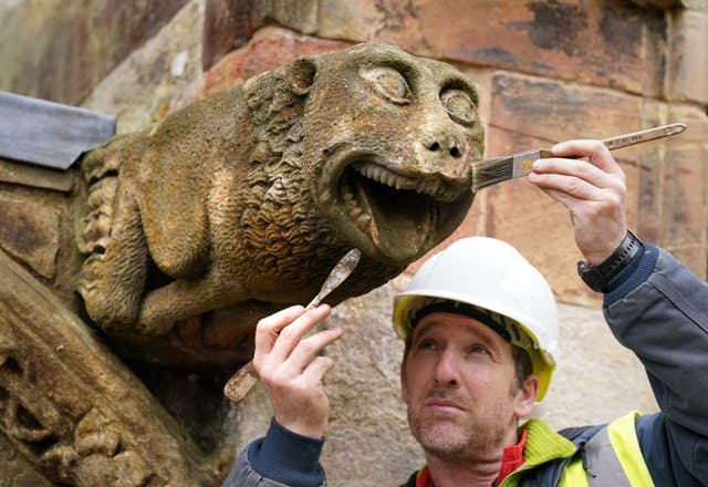 Alex Kelly from Eden Architectural Conservation cleans a gargoyle on the north doorway at Rosslyn Chapel in Roslin, Midlothian, as part of conservation maintenance