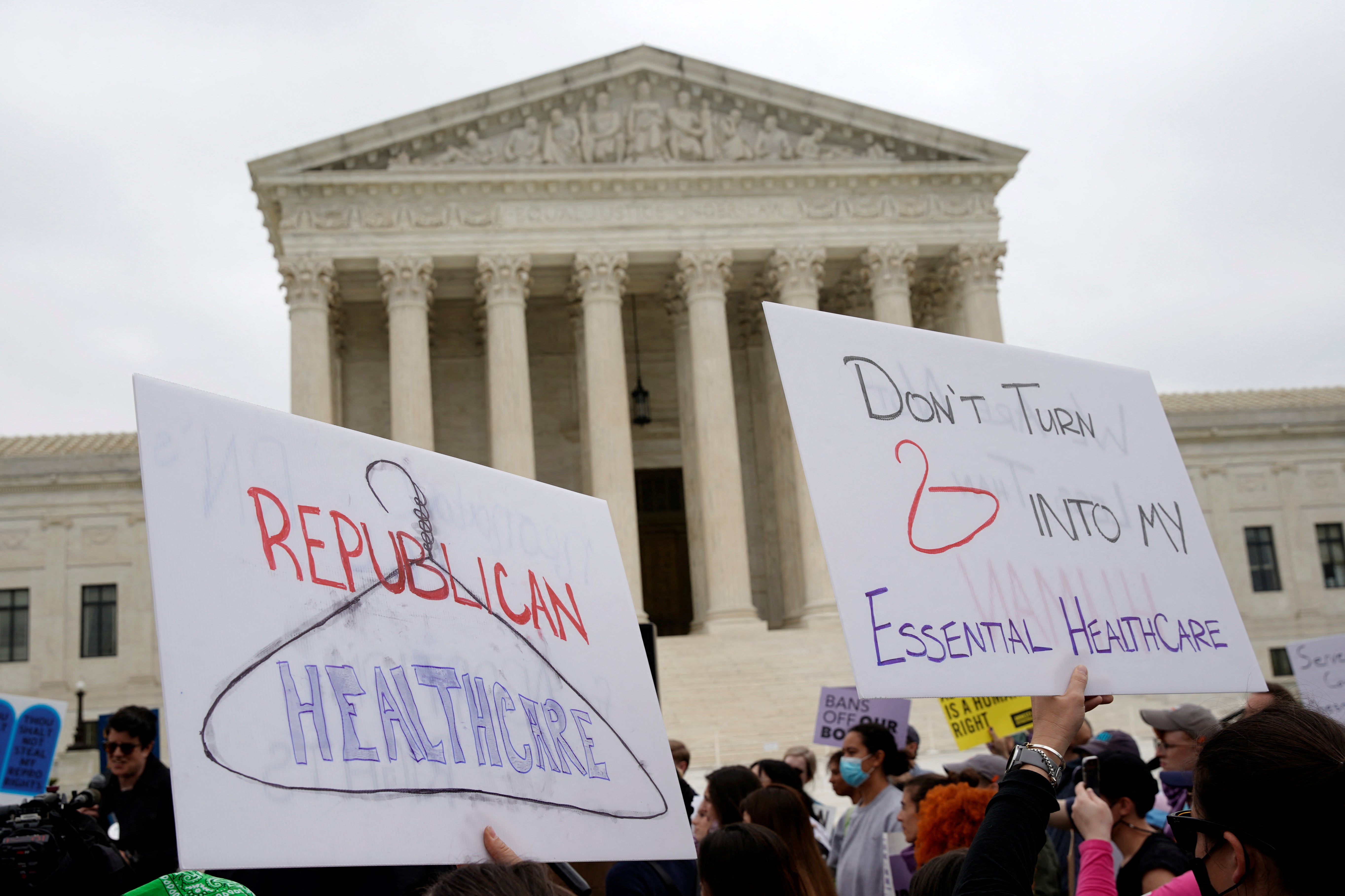 Demonstrators hold up signs during a protest outside the US Supreme Court over leaked document suggesting the overthrow of Roe v Wade