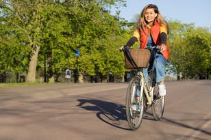 A woman rides her bicycle for outdoor exercise (Alamy/PA)
