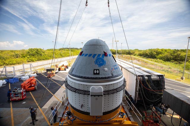 <p>The Boeing Starliner is prepared to mounting on a rocket ahead of a 19 May flight test</p>