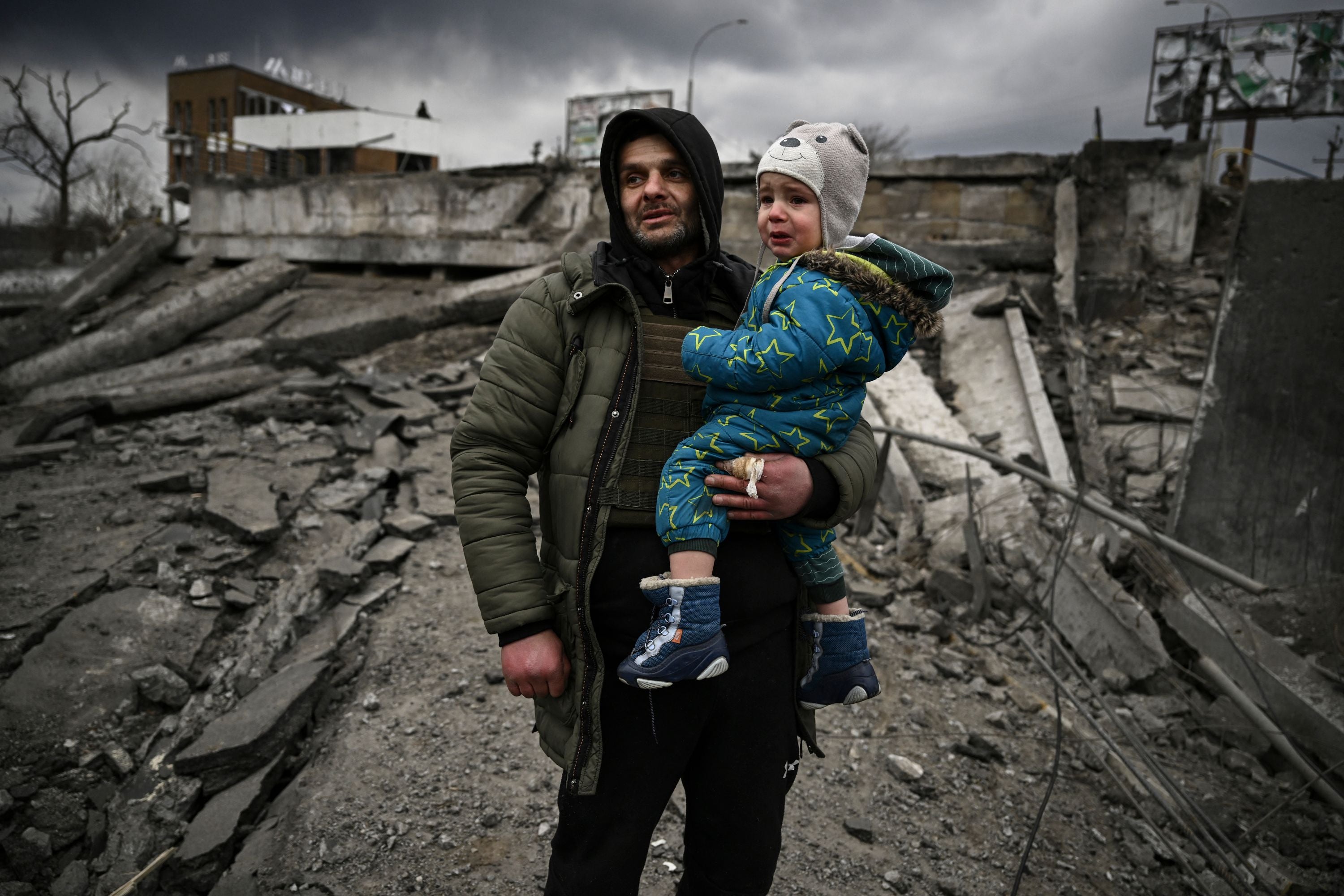 A man and his child flee Irpin, west of Kyiv