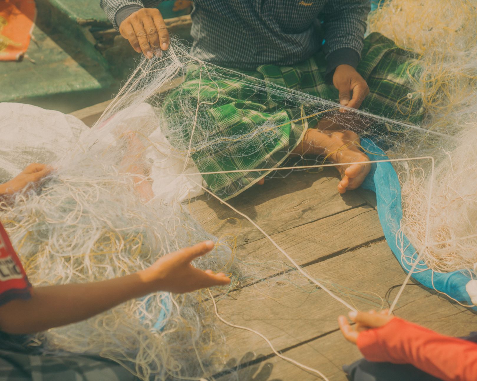 Fishermen untangling their fishing nets on the boat after a long day of fishing