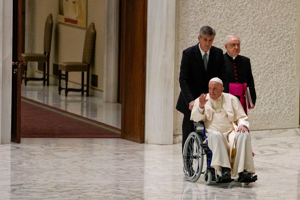 Pope, suffering knee pain, uses wheelchair for 1st time