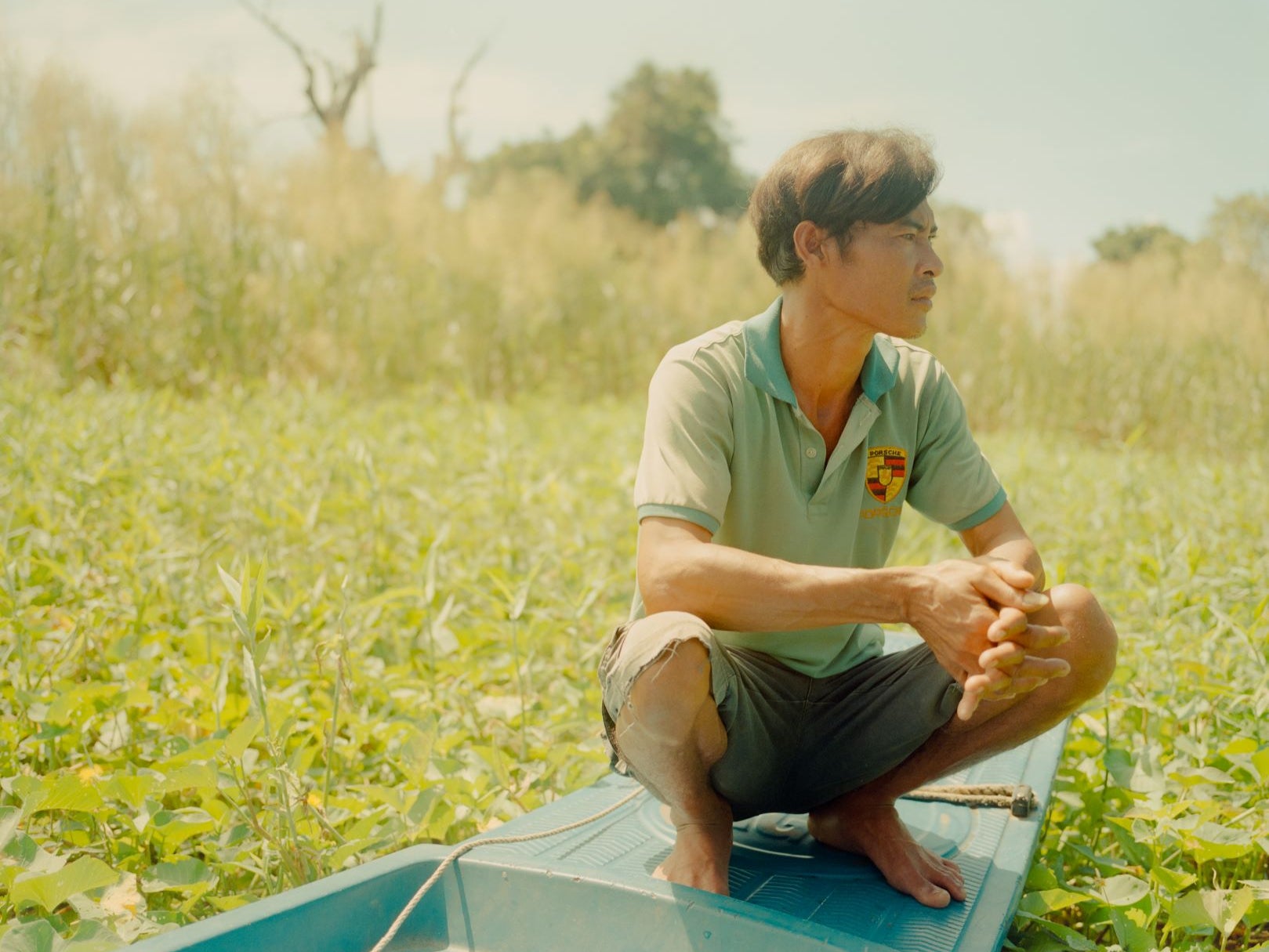 Lim Ny on his boat in the backyard of his home, Phat Sanday floating village