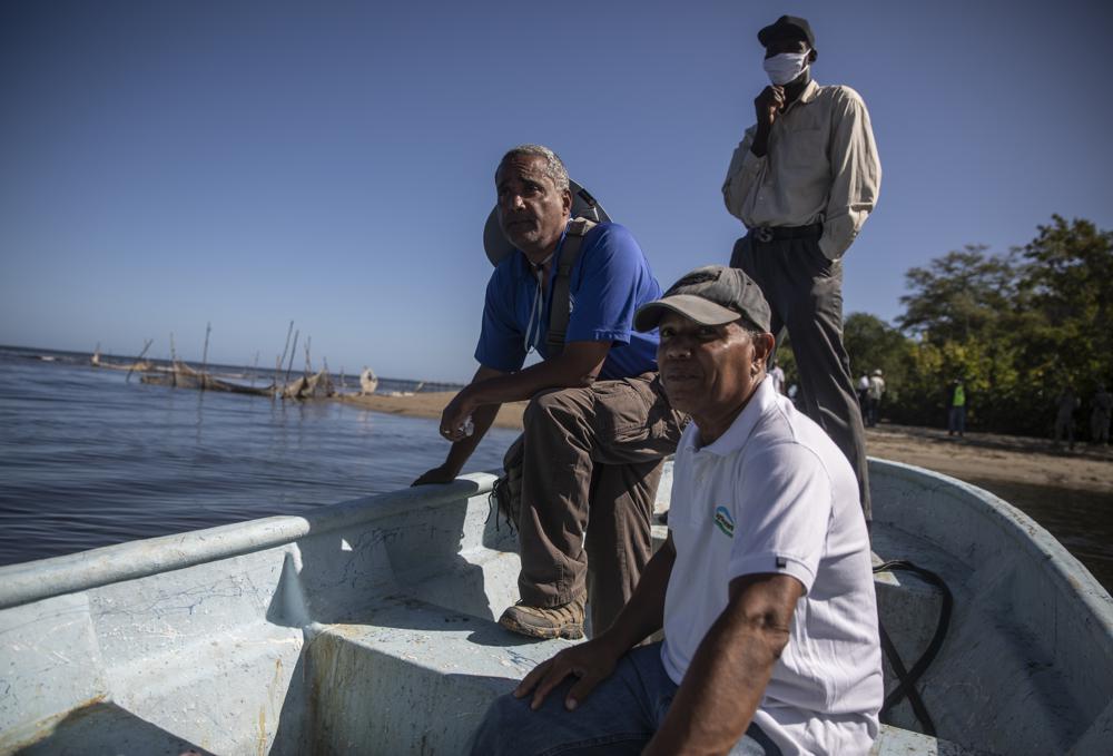Agronomist and horticulturalist Frederick Payton, right, and marine biologist Jean Wiener, left centre, cross the Massacre River in order to attend a rare face-to-face meeting between fishermen from Haiti and the Dominican Republic, in Fort-Liberte