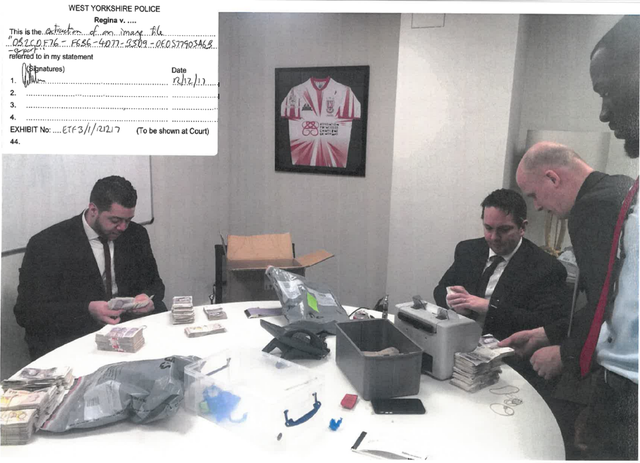 <p>This image shown to a jury at Leeds Cloth Hall Court shows cash piled on a table alongside a banknote counting machine at James Stunt’s London office</p>