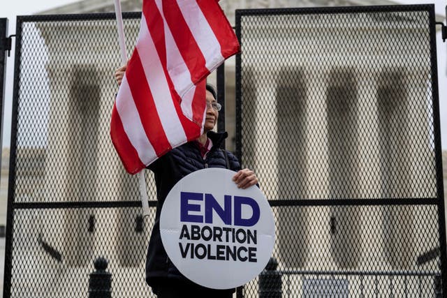 Un manifestante pro-vida se para frente a una cerca no escalable que se encuentra alrededor de la Corte Suprema de EE. UU. en Washington, DC, el 5 de mayo de 2022.
