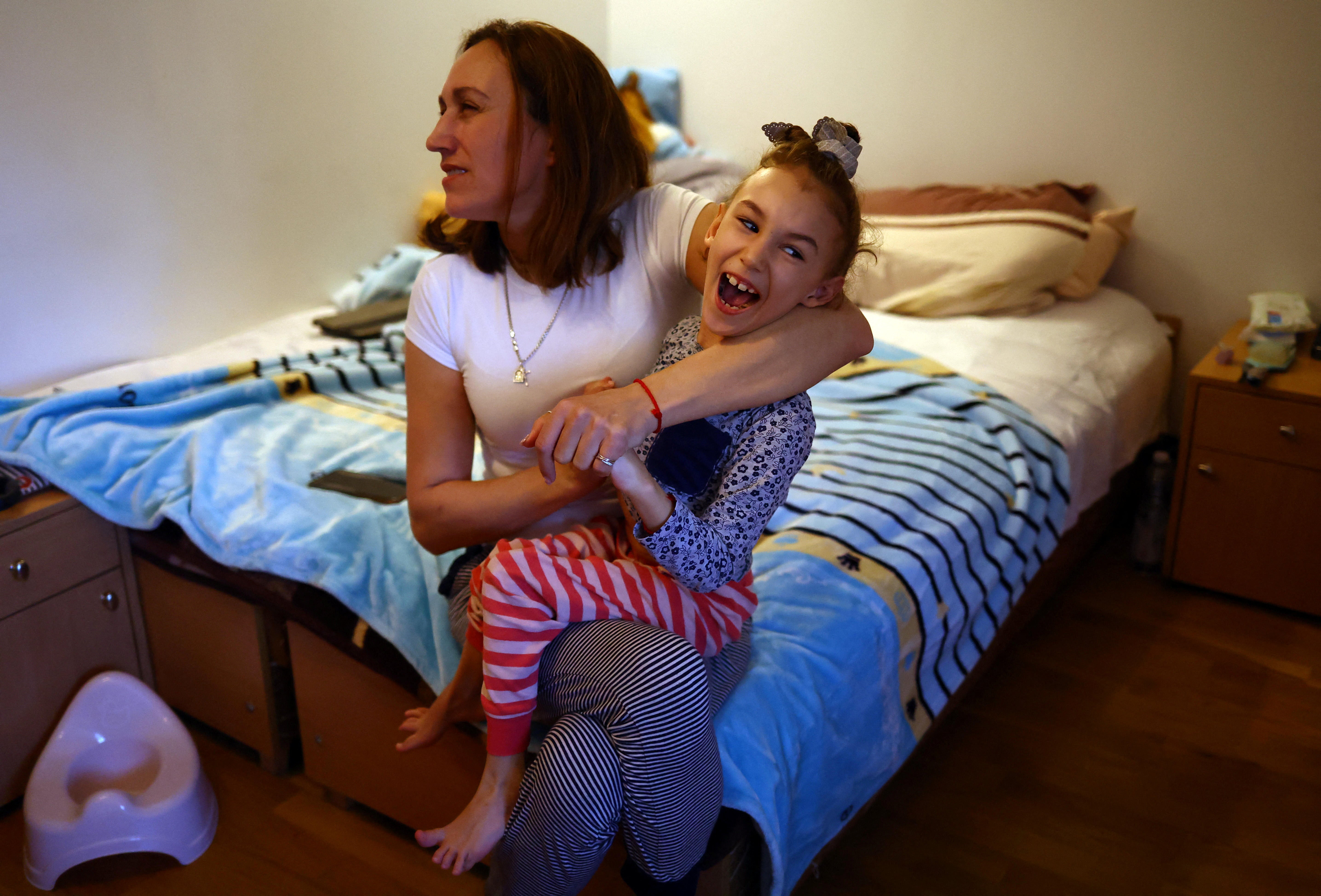 Alexandra Zhuravel holds her daughter, Alevtina, in their bedroom at the Benedictine Sisters Monastery
