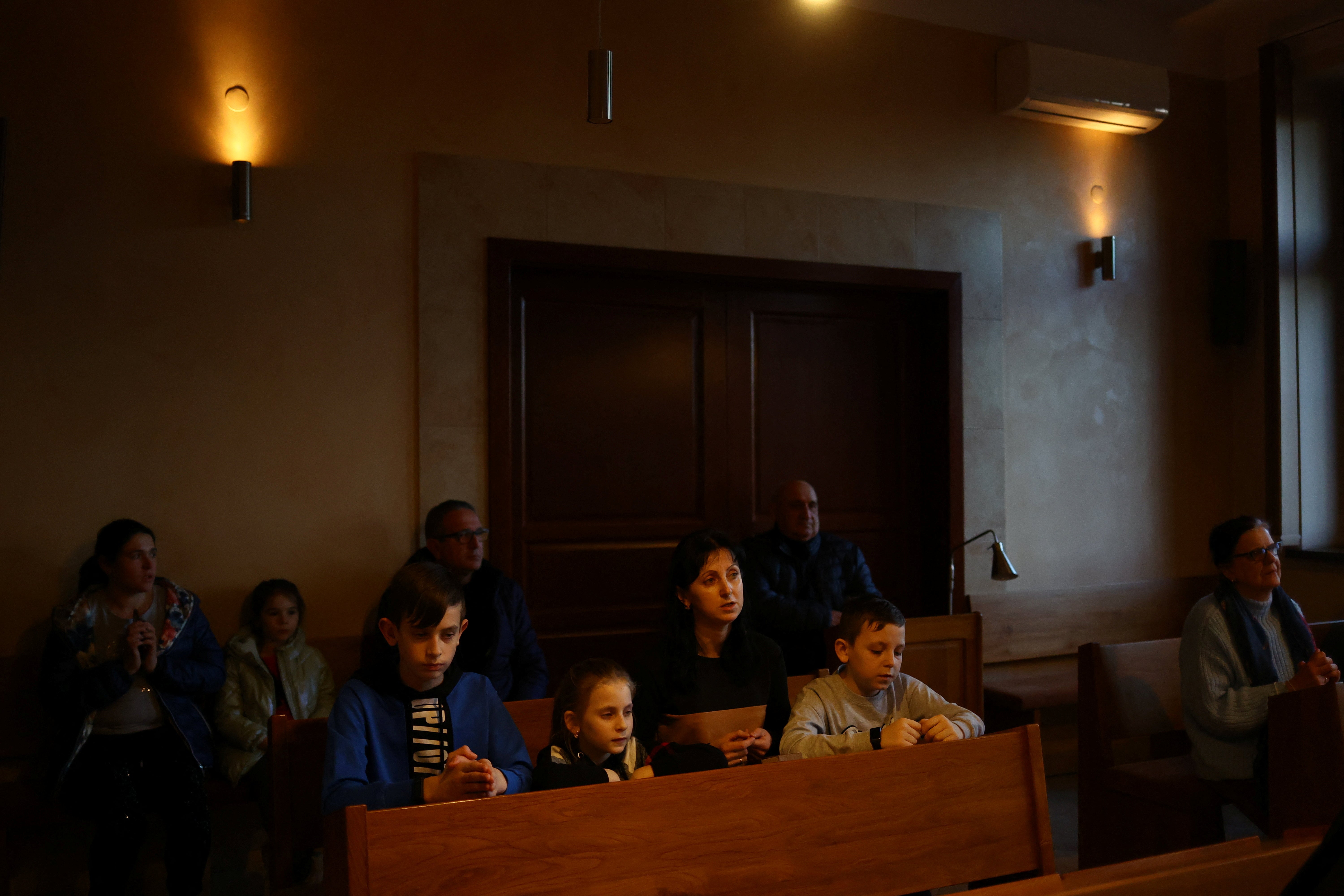 Ukrainian refugees pray during a service at the Benedictine Sisters Monastery