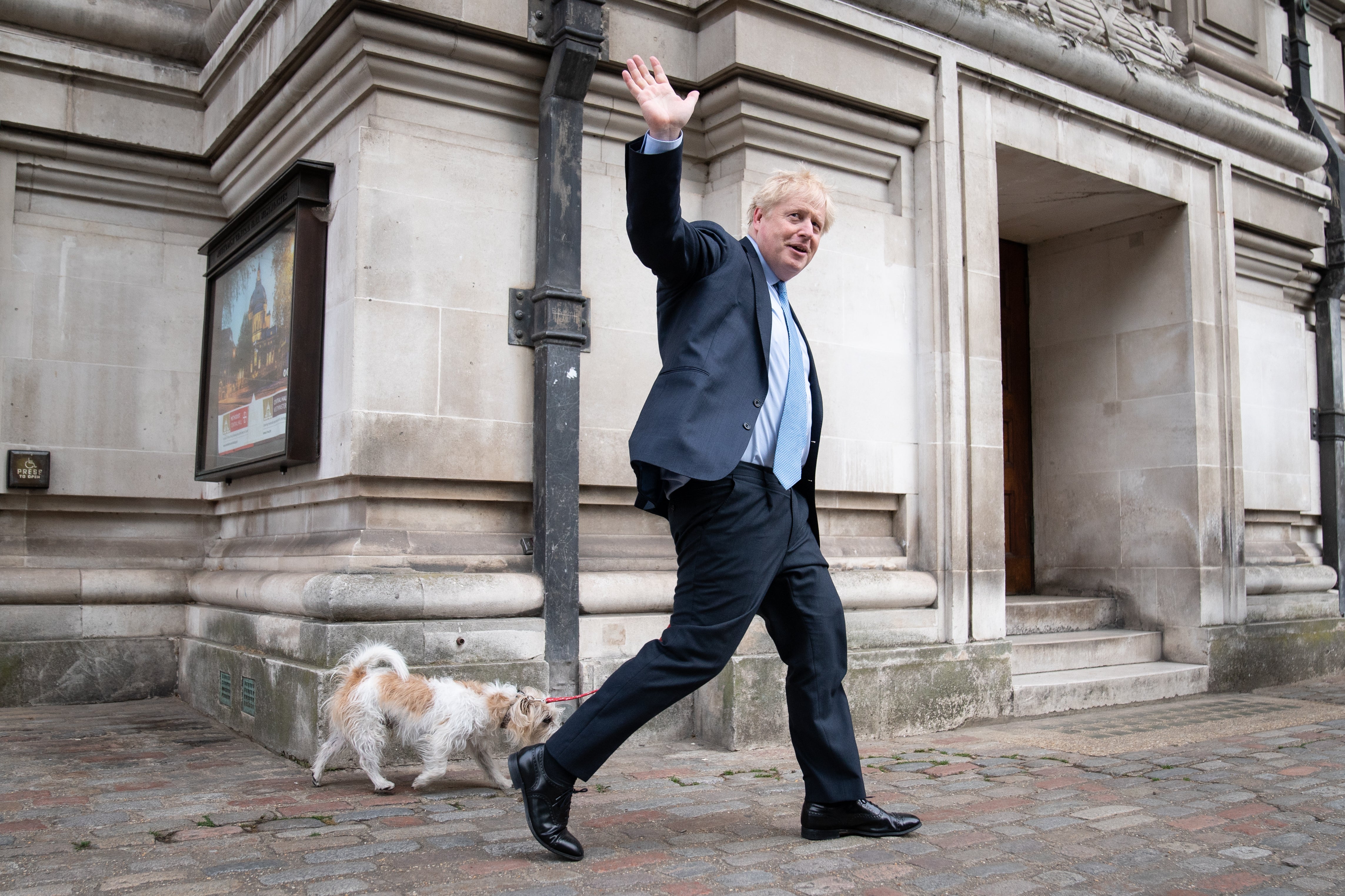 Prime Minister Boris Johnson leaves Methodist Central Hall in London with his dog, Dilyn, after voting in the local government elections (PA)