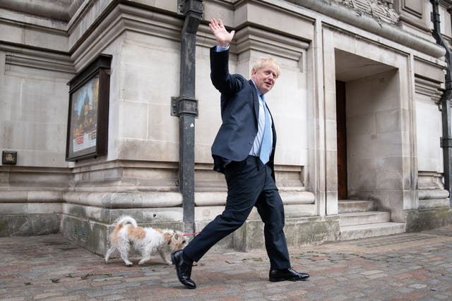 Prime Minister Boris Johnson leaves Methodist Central Hall in London with his dog, Dilyn, after voting in the local government elections (PA)