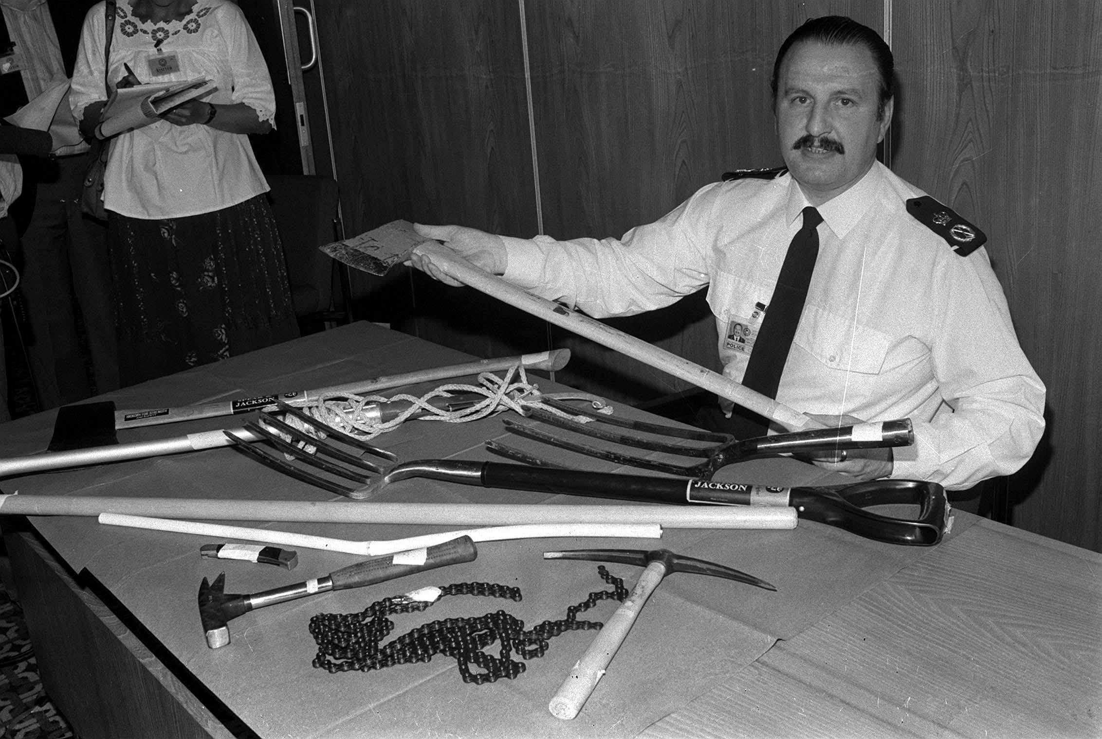 Then chief constable of the Greater Manchester Police, James Anderton, displaying some of the items that were looted and used by rioters as weapons during the riots in the Moss Side District of Manchester (Archive/PA)